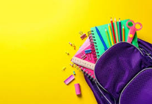 Image of a purple backpack with school supplies coming out of it.