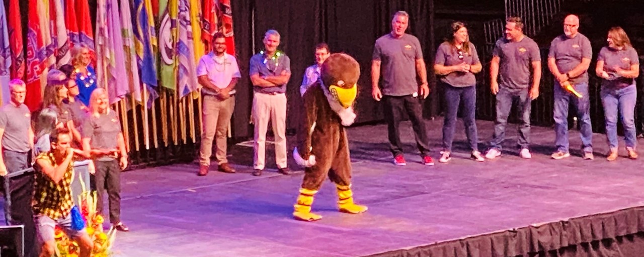 Image of the 2022-23 CUSD General Session Event Showing the Clovis West Eagle Mascot on stage with administrators standing around him.